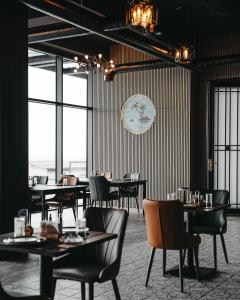 a restaurant with tables and chairs and a clock on the wall at Port Marine Hotel By HOLLYWOOD in Baku