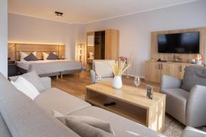 a living room with a couch and a bed and a table at Chalet Bergzeit Family Wellness Suite in Braunlage