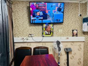 a room with a table and a tv and a fan at Lodge on 98 Alexander in Parow