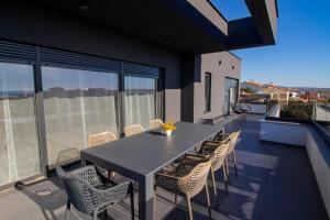 a patio with a table and chairs on a balcony at Black Diamond in Novalja