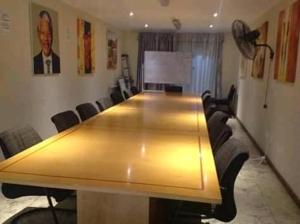 a conference room with a large wooden table and chairs at Lodge on 98 Alexander in Parow