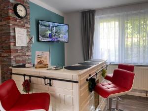 a waiting room with two red chairs and a desk at Ferienwohnung Joli- inklusive Parkplatz, Bettwäsche, Handtücher und WLAN in Weißenfels