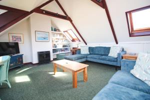 ein Wohnzimmer mit blauen Sofas und einem Couchtisch in der Unterkunft ON THE BEACH holiday home in Saint Merryn