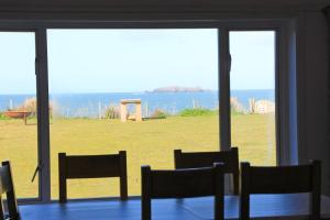 ein Raum mit Tisch und Stühlen und einem großen Fenster in der Unterkunft ON THE BEACH holiday home in Saint Merryn + 15 Fotos