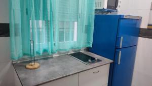 cocina con fregadero y nevera azul en Apartamento Pacífico, en Chipiona