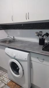 una cocina con lavadora y fregadero en Apartamento Pacífico, en Chipiona 26 fotos más