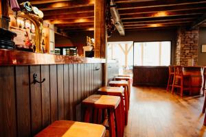 a row of wooden tables and chairs in a restaurant at The Fleece at Ruleholme in Carlisle