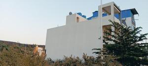 a white building with a camera on the side of it at Sukhada Nivas Bunglow in Trimbak