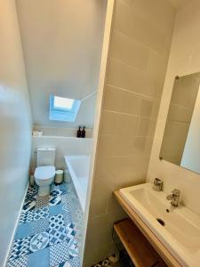 a bathroom with a toilet and a tub and a sink at Perle Marine Haussmannienne - Lumineux & Calme - Proche Gare & Plage in Dieppe