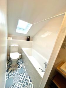 a bathroom with a toilet and a bath tub at Perle Marine Haussmannienne - Lumineux & Calme - Proche Gare & Plage in Dieppe