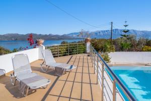 a balcony with two chairs and a swimming pool at Luxury Villa in Nikiana with Stunning Views in Nikiana