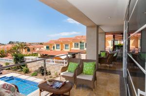 a balcony with chairs and a view of a house at Sonnenland House for 12 by VillaGranCanaria in Maspalomas