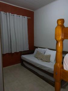 a bedroom with a bed with a wooden bed frame at Rancho Bertotti in Guaratuba