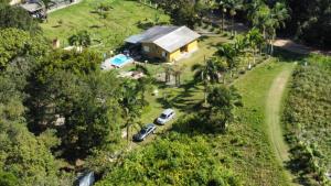 an aerial view of a house with cars parked in front at Rancho Bertotti in Guaratuba