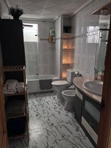 a bathroom with a toilet and a tub and a sink at Casa Sempere in Elche