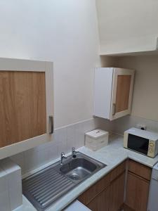 a small kitchen with a sink and a microwave at Bank Top Farm Cottages in Stoke on Trent +40 photos