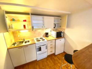 a small kitchen with a sink and a stove at Pink Gem, Kamppi in Helsinki