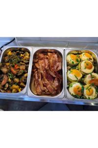 a tray of food with eggs and meat and vegetables at Greg&Tom Beer House Hostel in Krakow