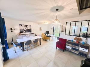 a kitchen and living room with a table and chairs at Maison lumineuse avec jardin entre plages de Cap-Coz et Beg-Meil, proche activités nautiques - FR-1-481-173 in Fouesnant