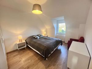 a bedroom with a bed and a chair and a window at Maison lumineuse avec jardin entre plages de Cap-Coz et Beg-Meil, proche activités nautiques - FR-1-481-173 in Fouesnant