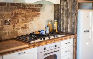 a kitchen counter with a stove and a refrigerator at Apartment Casa Norina in Notaresco