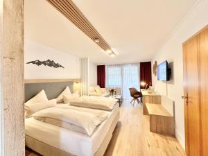 a hotel room with a large bed and a desk at Yachthotel Chiemsee GmbH in Prien am Chiemsee