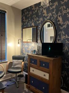 a bedroom with a mirror and a dresser and a chair at Kelston Guest House in Weymouth