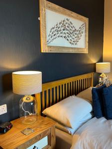 a bedroom with a bed and a table with a lamp at Kelston Guest House in Weymouth