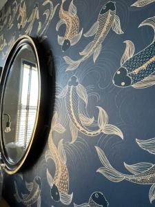 a bathroom with a mirror and a wallpaper with koi at Kelston Guest House in Weymouth