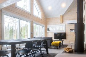 a living room with a table and chairs and a tv at Villa Hiili in Sonkajärvi