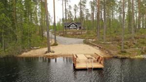 a house in the middle of a lake with a dock at Villa Hiili in Sonkajärvi