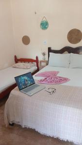 a laptop computer sitting on top of a bed at BELL MAR CHALéS 01e 02 in Luis Correia +32 photos