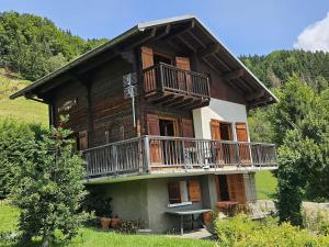 a large wooden house with a balcony at Le Mazot du Genévrier - Au coeur des Aravis in Les Clefs