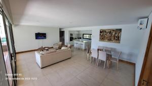 ein Wohnzimmer mit einer Couch und einem Tisch und Stühlen in der Unterkunft Laderas de Chacras vista montaña en Barrio privado in Ciudad Lujan de Cuyo