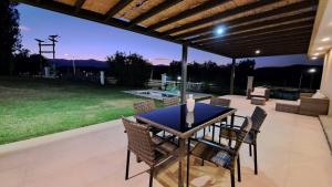einen Tisch und Stühle auf einer Terrasse mit Aussicht in der Unterkunft Laderas de Chacras vista montaña en Barrio privado in Ciudad Lujan de Cuyo