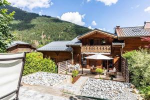 a log house with a deck and a patio at Chalet Abricotine, sleeps 10, Hot tub in Saint-Jean-dʼAulps