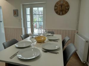a table with plates and wine glasses and a clock at House with pool Ideal for 8 guests in Rimons