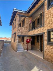 a brick building with a red sign in front of it at Cloveridge 104 in Benoni