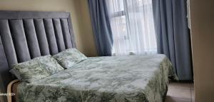 a bedroom with a bed and a window with curtains at Cloveridge 104 in Benoni