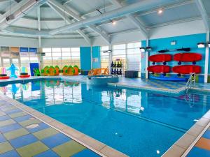 ein großer Pool mit blauem Wasser und roten Stühlen in der Unterkunft Sea Bliss Beachfront Caravan, 2 Bed King Ensuite, Sleeps 6, Wrap Decking, Crimdon Dene in Hartlepool