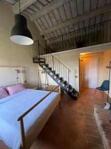 a bedroom with a bed and a spiral staircase at La Falconara in Montepulciano +92 photos