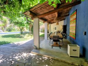 Robion en LuberonにあるLe Mas Rose Théの木製の屋根の下にテーブルと椅子付きのパティオ