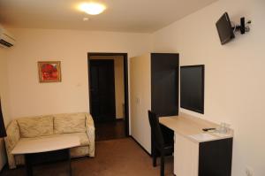 a living room with a couch and a desk in a room at Hotel Balkan in Botevgrad