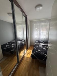 a bedroom with two beds and a mirror at Bijeljina Central in Bijeljina