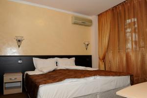 a bedroom with a large bed and a window at Hotel Balkan in Botevgrad