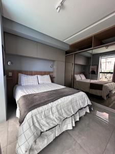 a bedroom with a large bed and a mirror at Flat Beira mar em Tambaú in João Pessoa
