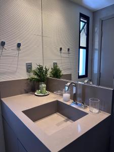 a bathroom counter with a sink and a mirror at Flat Beira mar em Tambaú in João Pessoa