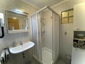 a white bathroom with a sink and a shower at Kössler, Appartementhaus in Bad Hofgastein