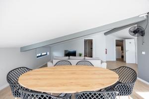 ein Esszimmer mit einem Holztisch und Stühlen in der Unterkunft Palm Breeze Loft in Estreito da Calheta