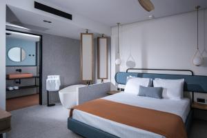 une chambre avec un grand lit et une salle de bain dans l'établissement Harmony Boutique Resort - Adults oriented, à Georgioúpoli